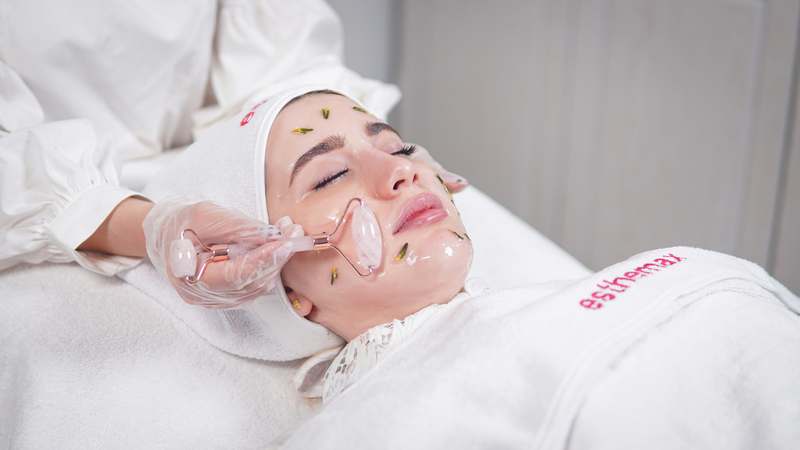 Woman applying tinted moisturizer with dewy, natural-looking skin in soft daylight